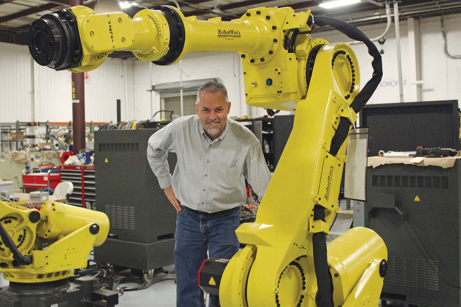 Chris Hurd, a Cazenovia High School technology teacher, is pictured at the Ohio factory Robotworx, where he went for training in using a robotic arm. (The one used in the classroom is much smaller.)