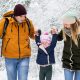 Family hiking through snow covered forest