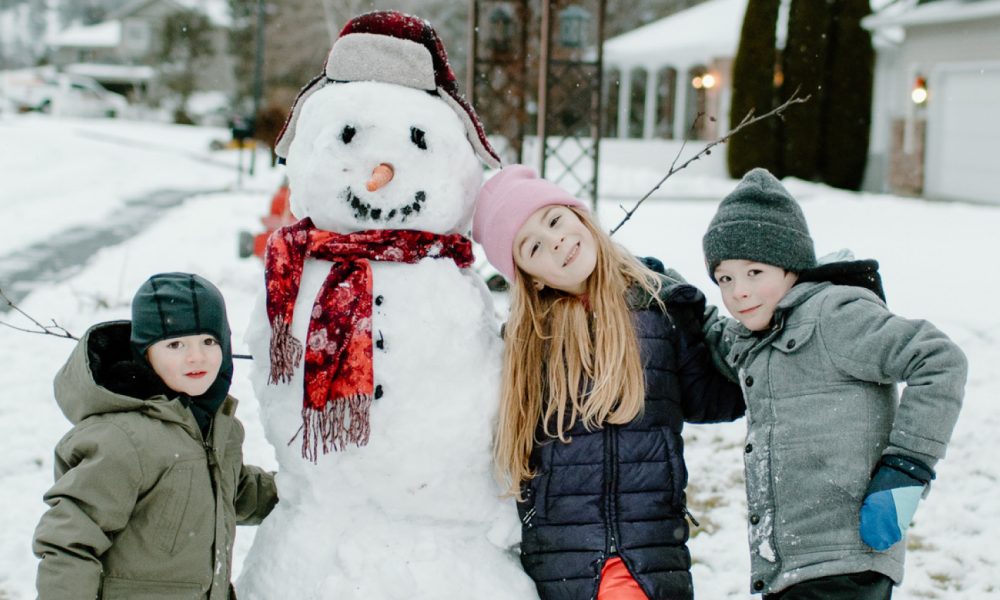 Kids standing with snowman