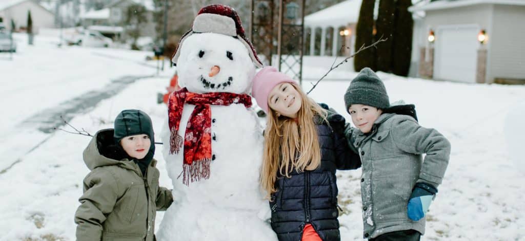 Kids standing with snowman