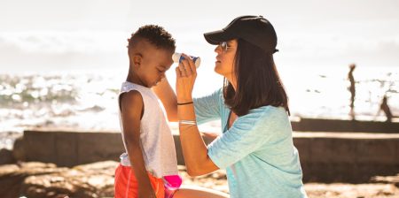 Mom applying sunscreen on young child