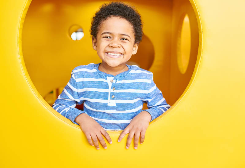 Boy playing inside on an indoor playground.
