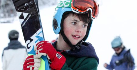 Boy with skis at ski resort.