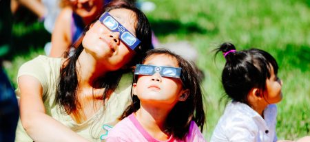 Mother and child wearing solar eclipse glasses