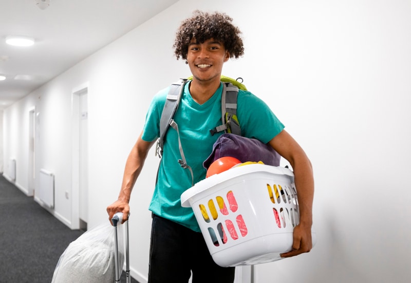 Male college student moving into dorm.