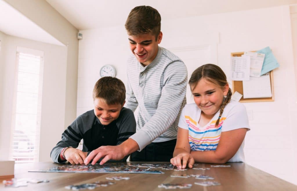 Three kids working on a puzzle.